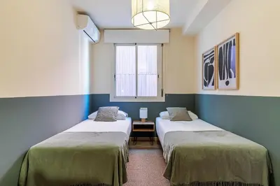 two beds in a small room with a window at AB Sagrada Familia - Sant Pau in Barcelona