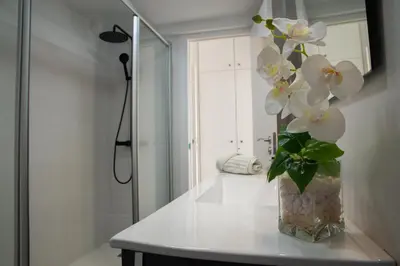 a vase with white flowers on a counter in a bathroom at Wonderful apartment in Gavà. Barcelona in Gavà