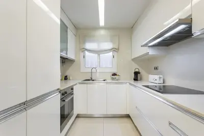 a white kitchen with a sink and a window at Apartamento en la playa de Castelldefels ( Barcelona) in Castelldefels