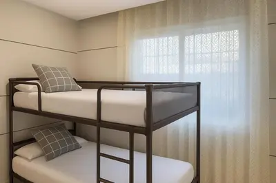 a bedroom with two bunk beds and a window at Apartamento en la playa de Castelldefels ( Barcelona) in Castelldefels
