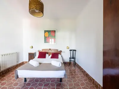 a bedroom with two beds with red and white pillows at Can Teulera in San Martín Sarroca