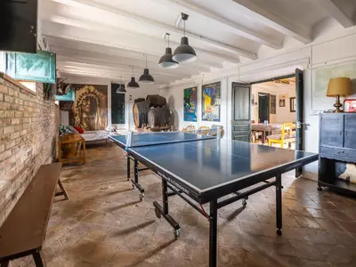 a ping pong table in a room with a brick wall at Can Teulera in San Martín Sarroca