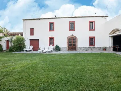 a large white building with a lawn in front of it at Can Teulera in San Martín Sarroca