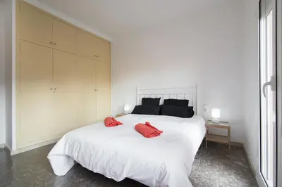 a bedroom with a large white bed with red pillows at Holiday home Splendid Park Güell in Barcelona