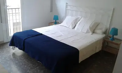 a bedroom with a large white bed with a blue blanket at Holiday home Splendid Park Güell in Barcelona
