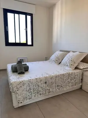 a white bed in a room with a window at Shome in Vilanova i la Geltrú