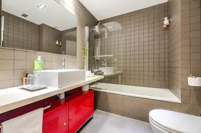a bathroom with a sink and a tub and a toilet at ArtlifeBCN Fira Apartment in Barcelona