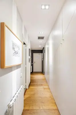 a hallway with white walls and a wooden floor at ArtlifeBCN Fira Apartment in Barcelona