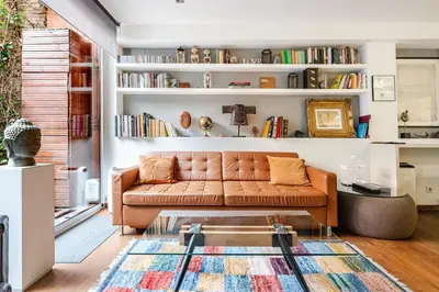 a living room with a brown couch and bookshelves at ArtlifeBCN Fira Apartment in Barcelona