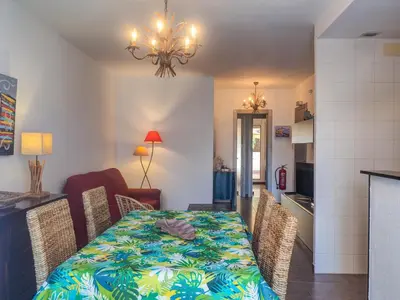 a dining room and kitchen with a table and chairs at Zafiro Apartment by Hello Homes Sitges in Sitges