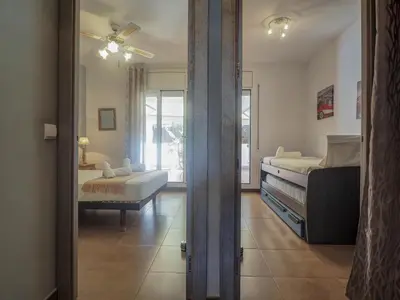 a bedroom with two beds and a living room at Zafiro Apartment by Hello Homes Sitges in Sitges
