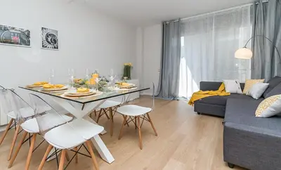 a living room with a table and chairs and a couch at Top family apartment by Lofties in Terrassa