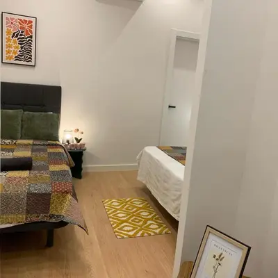 a room with a bed and a table with green pillows at Palau Rooms in Barcelona