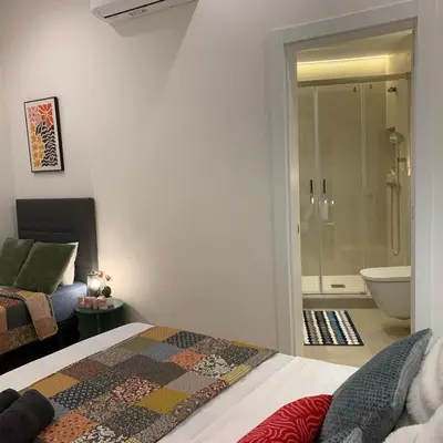 two beds in a room with a table and a desk at Palau Rooms in Barcelona