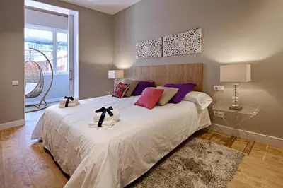 a bedroom with a large white bed with purple pillows at Habitat Apartments Barcelona Plaza in Barcelona