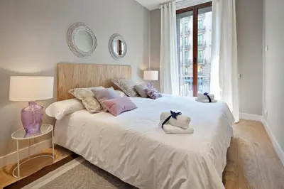 a bedroom with a large bed with two stuffed animals on it at Habitat Apartments Barcelona Plaza in Barcelona