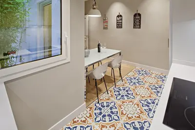 a kitchen with a table and chairs on a tile floor at Habitat Apartments Barcelona Plaza in Barcelona