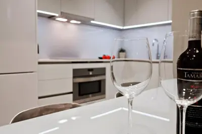a bottle of wine and two wine glasses on a table at Habitat Apartments Barcelona Plaza in Barcelona