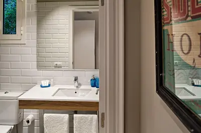 a white bathroom with a sink and a mirror at Habitat Apartments Barcelona Plaza in Barcelona