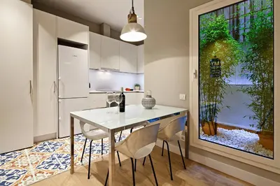 a kitchen with a white table and chairs in a room at Habitat Apartments Barcelona Plaza in Barcelona