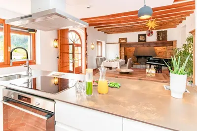 a kitchen with a counter top and a living room at La Terraza - Großzügiges Appartment in Katalanischer Masia in Sant Iscle de Vallalta