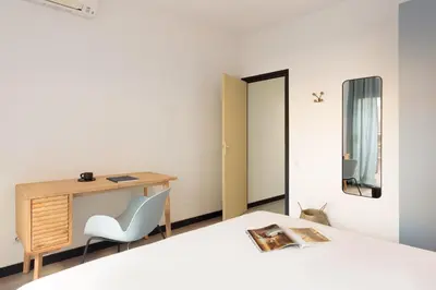 a bedroom with a desk and a chair and a bed at Maria Poblenou Apartment by Olala Homes in Barcelona