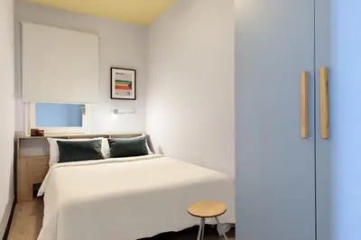 a bedroom with a white bed and a table at Maria Poblenou Apartment by Olala Homes in Barcelona