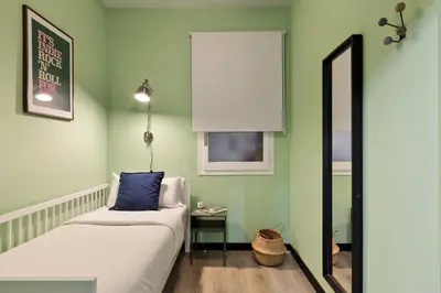 a room with a couch and a window and a mirror at Maria Poblenou Apartment by Olala Homes in Barcelona