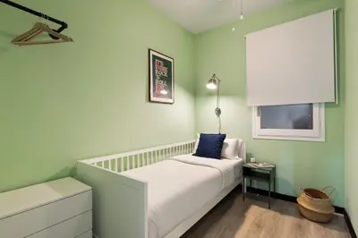 a small bedroom with a bed and a window at Maria Poblenou Apartment by Olala Homes in Barcelona