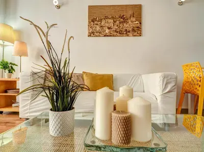 a living room with a couch and candles on a glass table at Espalter White by Hello Homes Sitges in Sitges