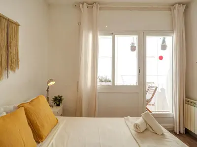 a bedroom with a white bed with a window at Espalter White by Hello Homes Sitges in Sitges
