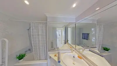 a white bathroom with a tub and a sink and a mirror at Premium Habitat Del Far in Arenys de Mar