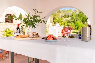 a white table with a plate of food and wine at El Huerto - Großzügiges Appartment in Katalanischer Masia in Sant Iscle de Vallalta