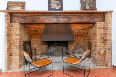 a brick fireplace with two chairs in front of it at Ginkgo - Familienfreundliches Appartment in Katalanischer Masia in Sant Iscle de Vallalta