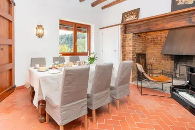 a dining room with a table and chairs and a fireplace at Ginkgo - Familienfreundliches Appartment in Katalanischer Masia in Sant Iscle de Vallalta