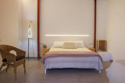 a bedroom with a large bed and a chair at Cal Teixidor in Mediona