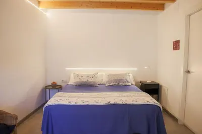 a bedroom with a bed with purple sheets and pillows at Cal Teixidor in Mediona