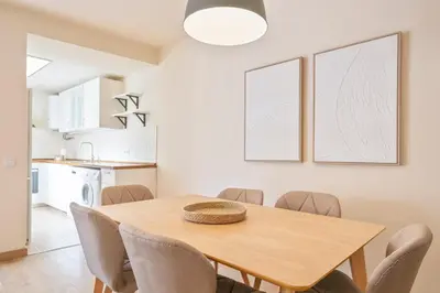 a kitchen and dining room with a wooden table and chairs at Alcam Galileu P in Barcelona