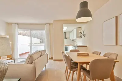 a dining room and living room with a table and chairs at Alcam Galileu P in Barcelona