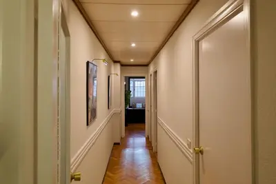 a hallway with white walls and wooden floors at Corcega - Sagrada Familia in Barcelona