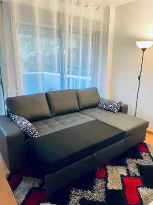 a black couch in a living room with a window at Luxe Forum Beach Terrace in Sant Adria de Besos
