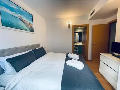 a bedroom with a large bed and a television at Luxe Forum Beach Terrace in Sant Adria de Besos