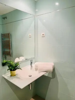 a bathroom with a sink and a mirror at Luxe Forum Beach Terrace in Sant Adria de Besos