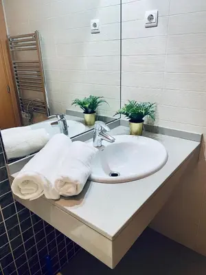 a bathroom with a sink with towels on it at Luxe Forum Beach Terrace in Sant Adria de Besos