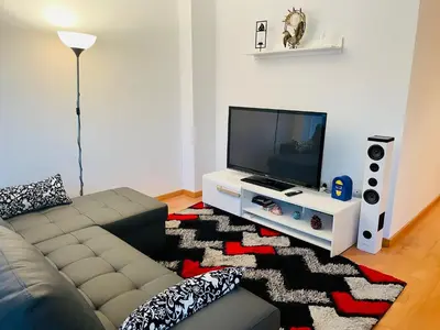 a living room with a couch and a flat screen tv at Luxe Forum Beach Terrace in Sant Adria de Besos