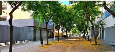 an empty street with trees in front of a building at Luxe Forum Beach Terrace in Sant Adria de Besos