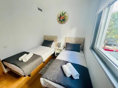 two twin beds in a room with a window at Luxe Forum Beach Terrace in Sant Adria de Besos