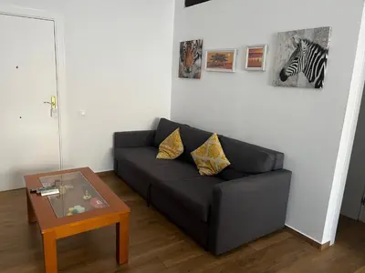 a living room with a couch and a table at Precioso apartamento con magnífico patio. in Sant Feliu de Llobregat