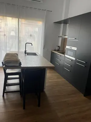 a kitchen with a island with a sink and a counter at Precioso apartamento con magnífico patio. in Sant Feliu de Llobregat