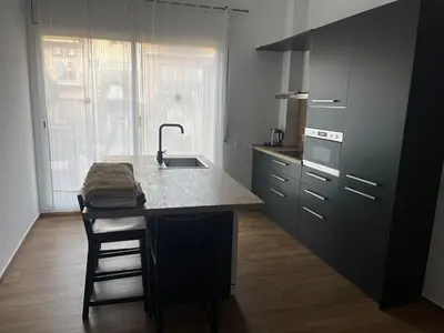 a kitchen with a island with a sink and a counter at Precioso apartamento con magnífico patio. in Sant Feliu de Llobregat